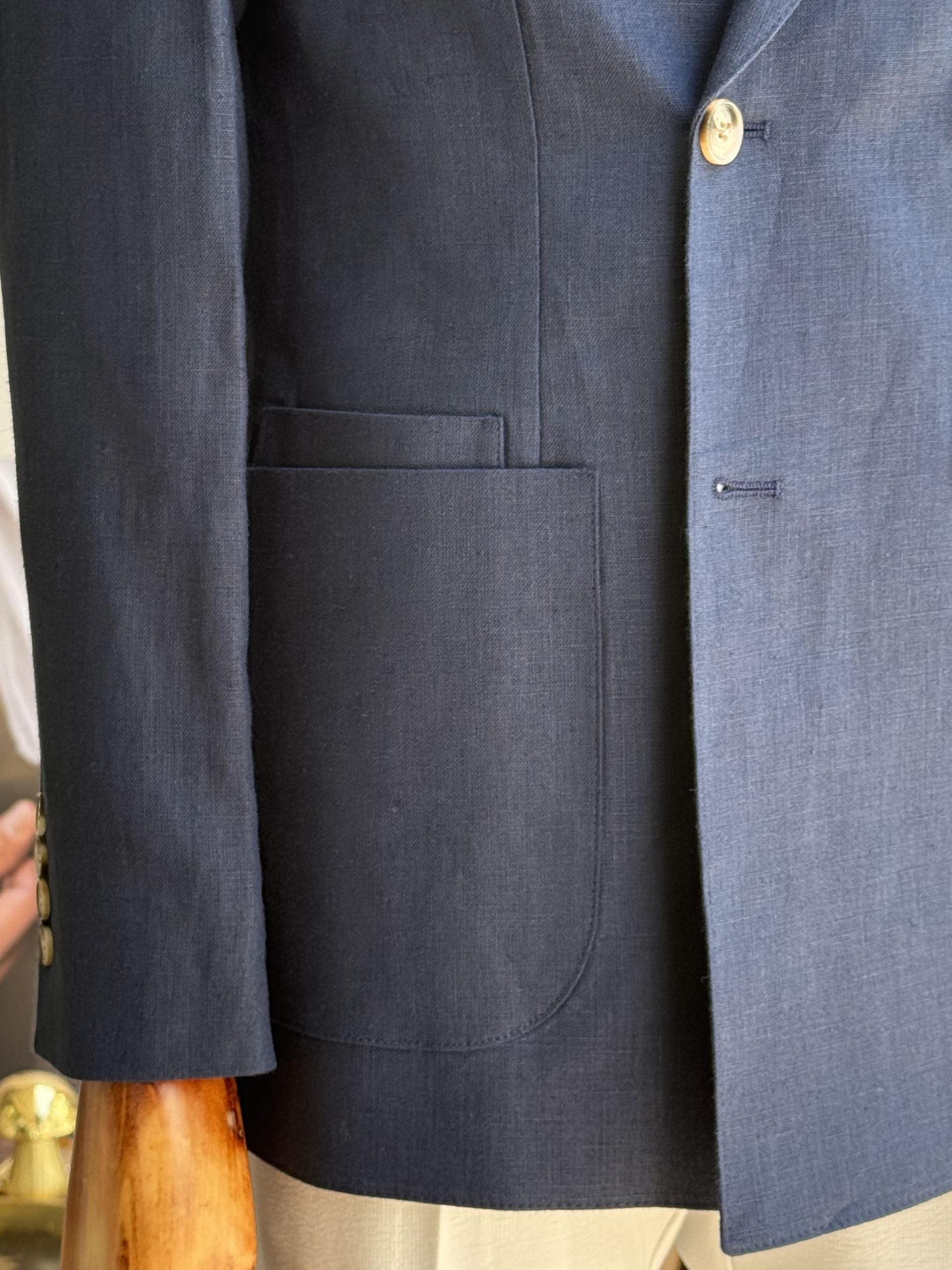 Navy double-breasted blazer displaying structured silhouette and lapel line, side view