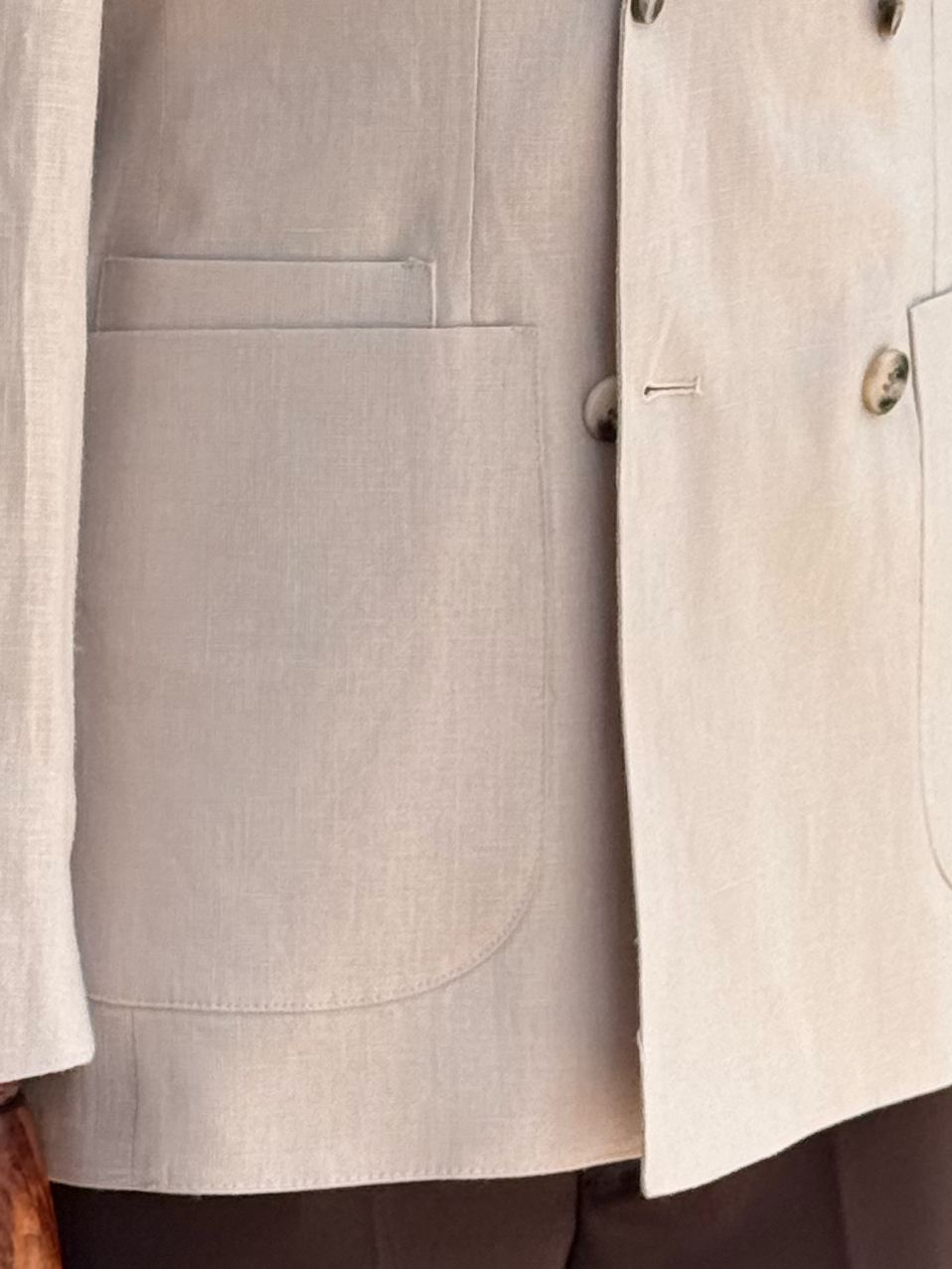 Beige double-breasted blazer displaying silhouette and lapel details, side angle