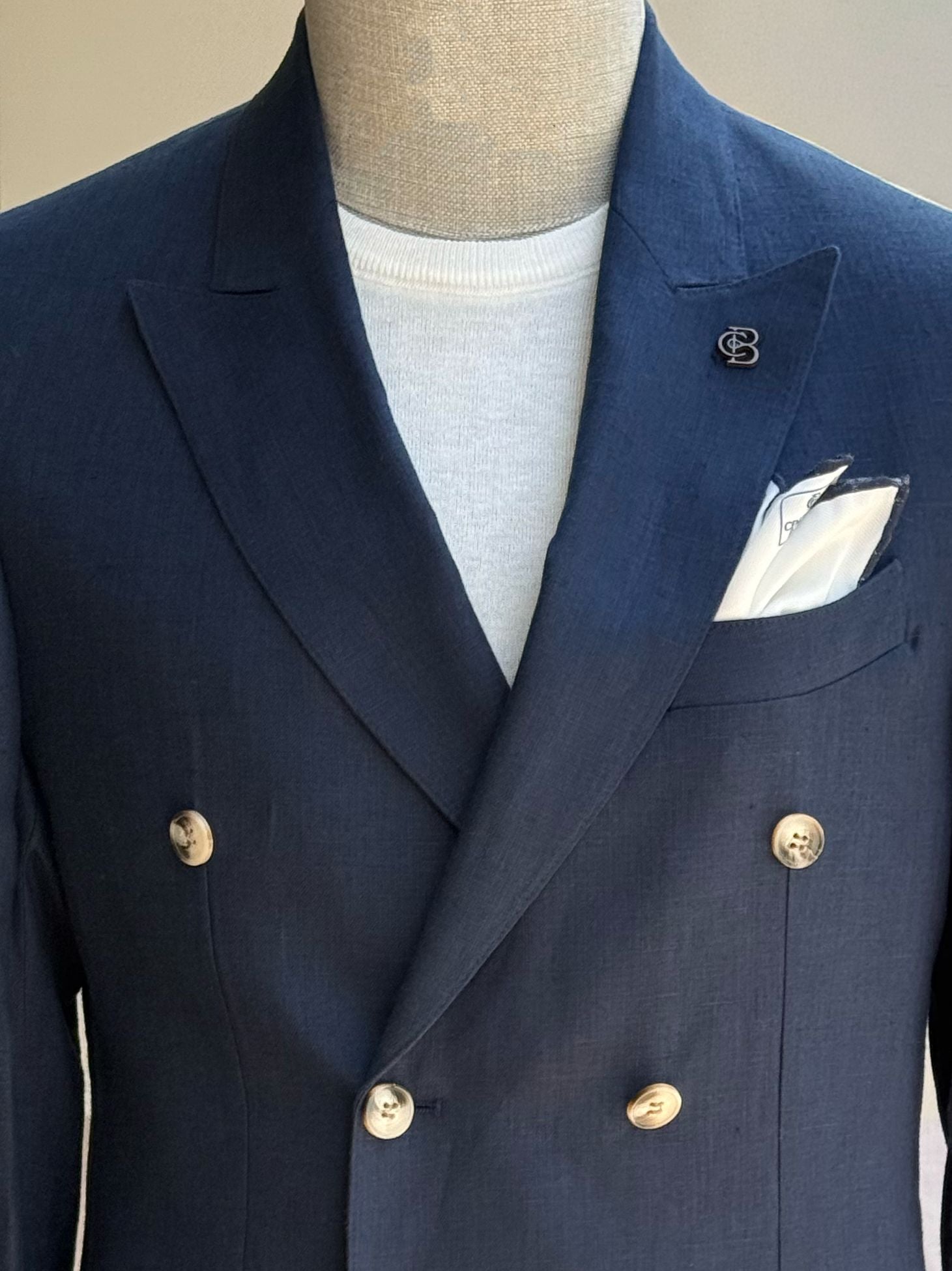 Navy double-breasted blazer showcasing back panel and center vent construction, back view