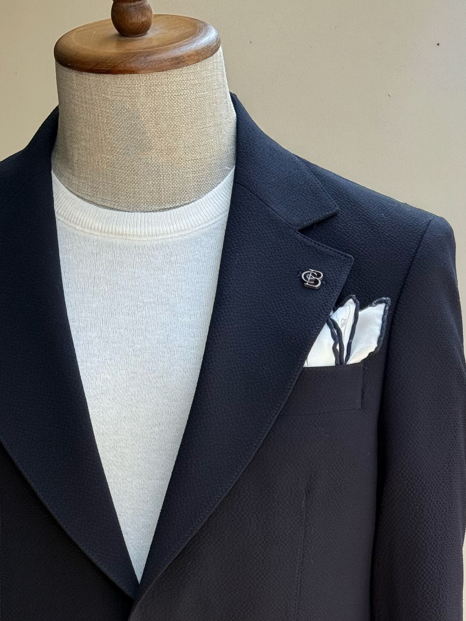 Navy single-breasted blazer showing tailored silhouette and sleeve construction, side view