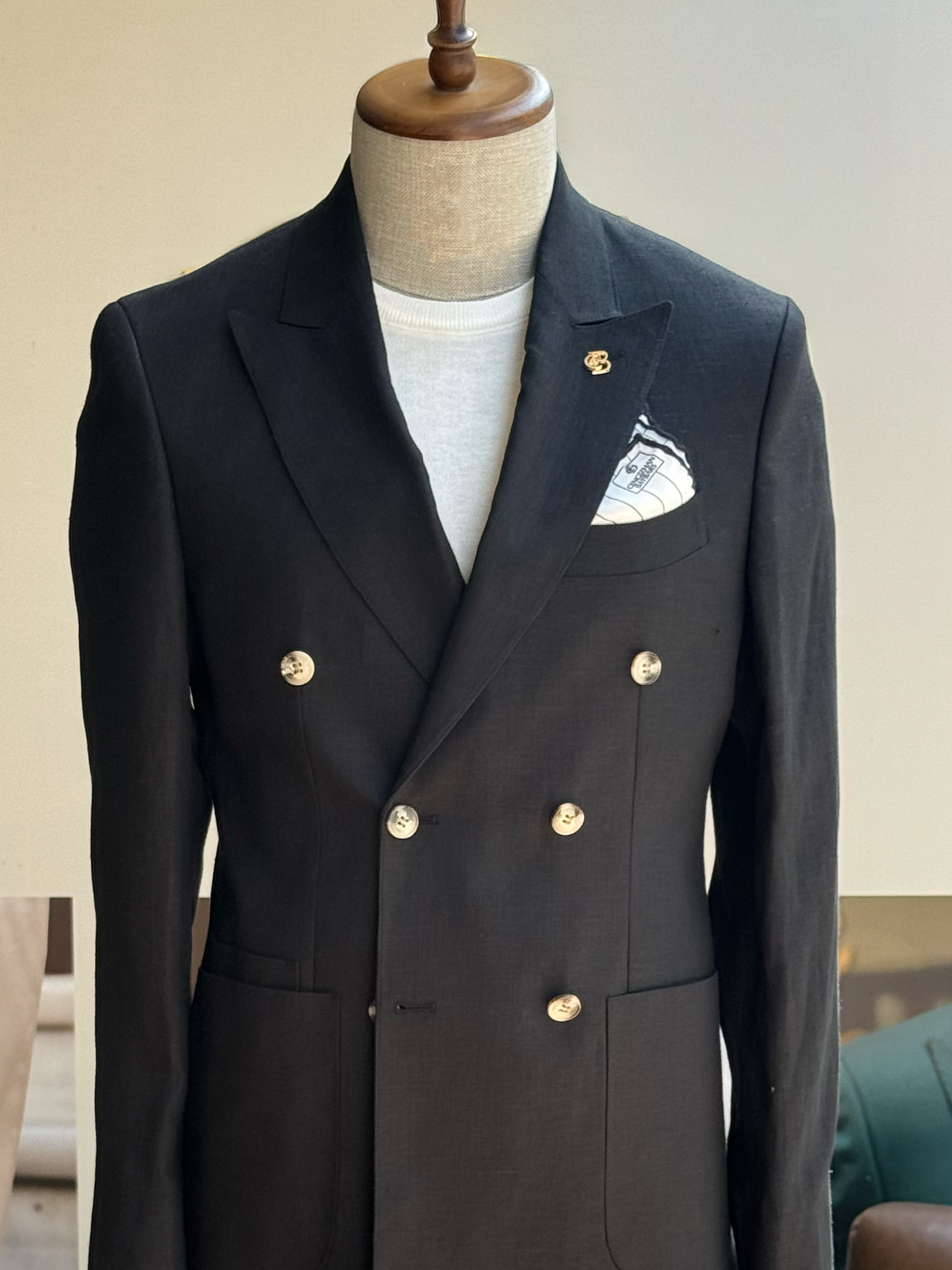 Black double-breasted blazer displaying tailored silhouette and lapel details, side view